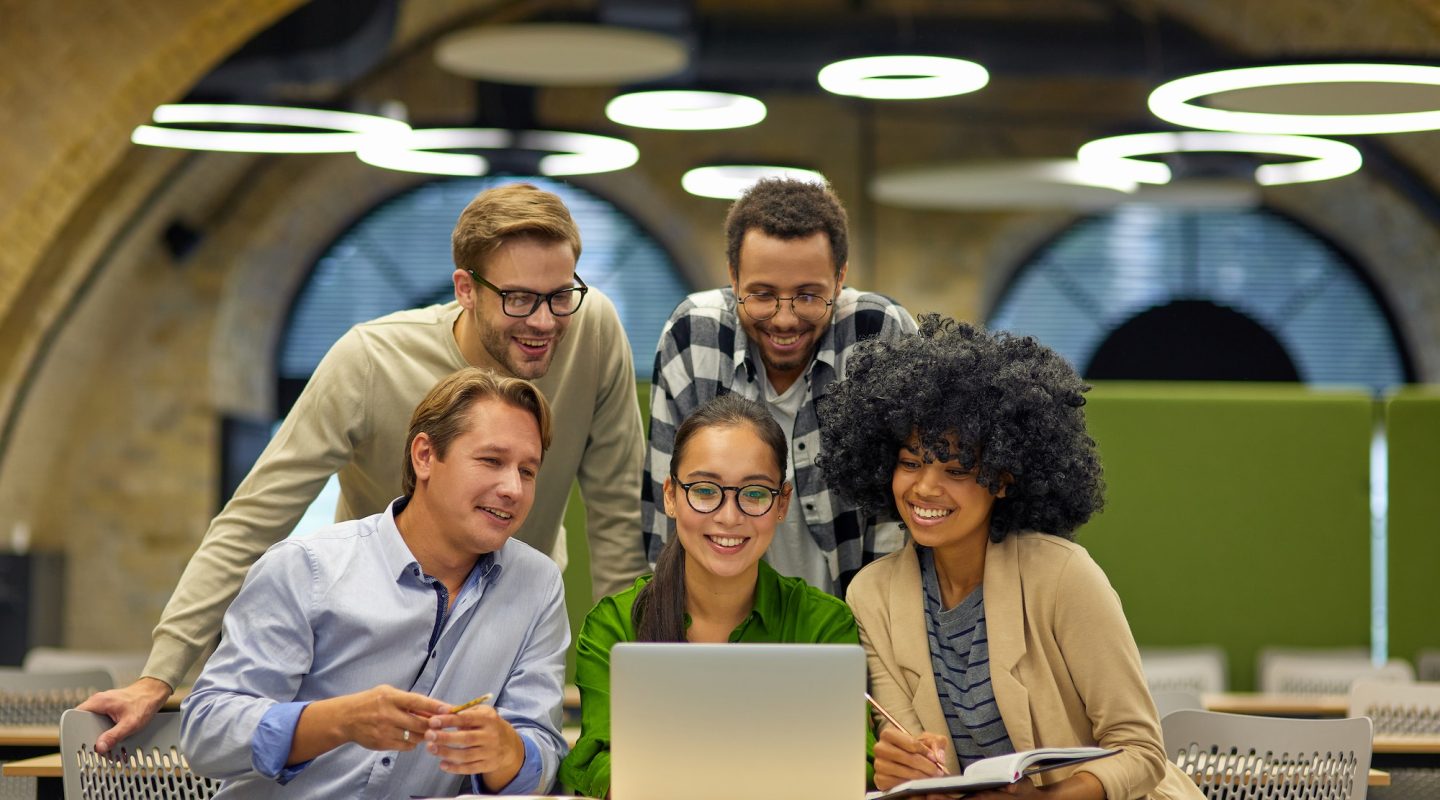 group-of-young-multiracial-business-people-sitting-at-desk-in-the-modern-coworking-space-looking-at.jpg